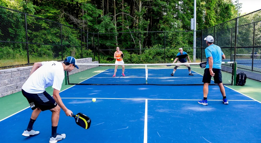 Adults playing pickleball in Burlington highlighting summer sports injuries prevention