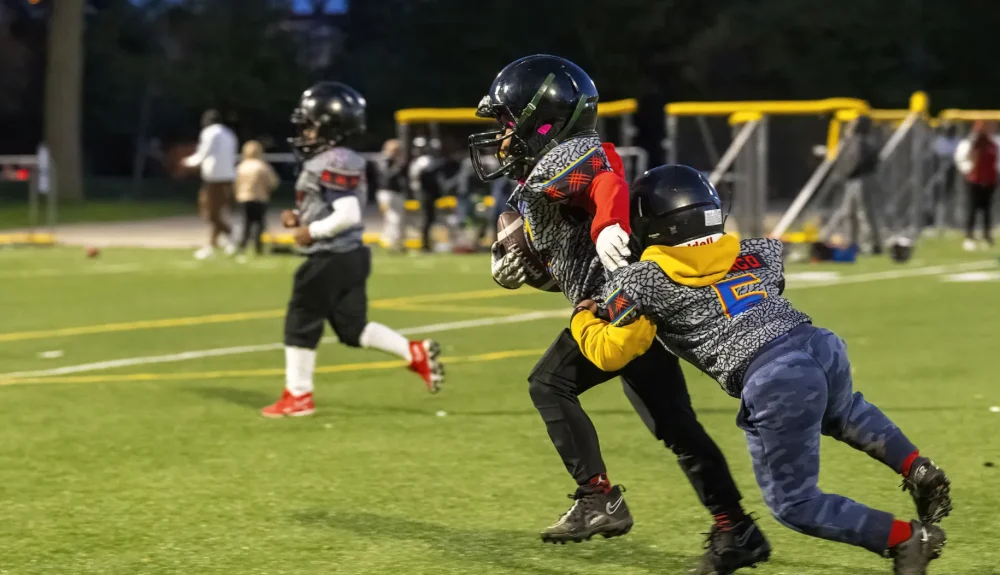 Young athletes playing football in Burlington highlighting youth sports injury prevention