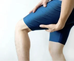 Athlete holding hamstring, muscle strain pain