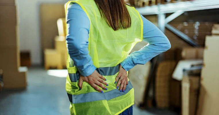 Warehouse worker with lower back pain at work